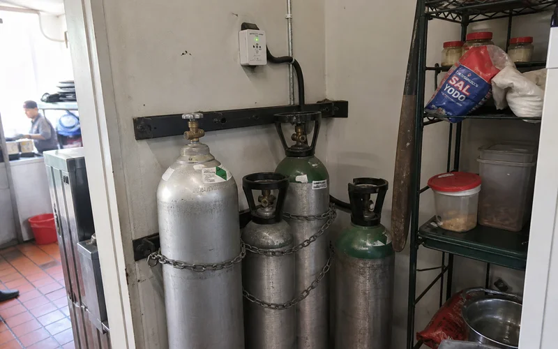 CO2 cylinders chained upright in a ventilated restaurant storage area