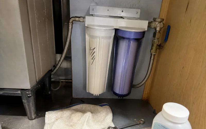 Dual cartridge filtration manifold plumbed into an ice machine water supply