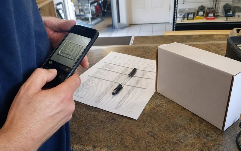 Equipment data plate being matched against a replacement part on a parts counter