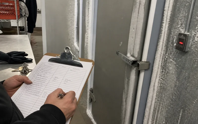 Handwritten temperature and time log during a freezer alarm event