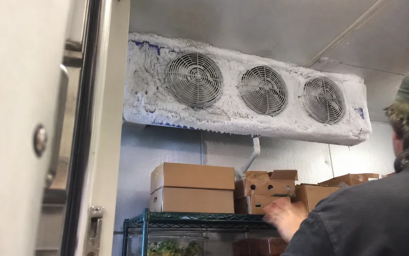 Frost buildup on a walk-in cooler evaporator coil blocking airflow