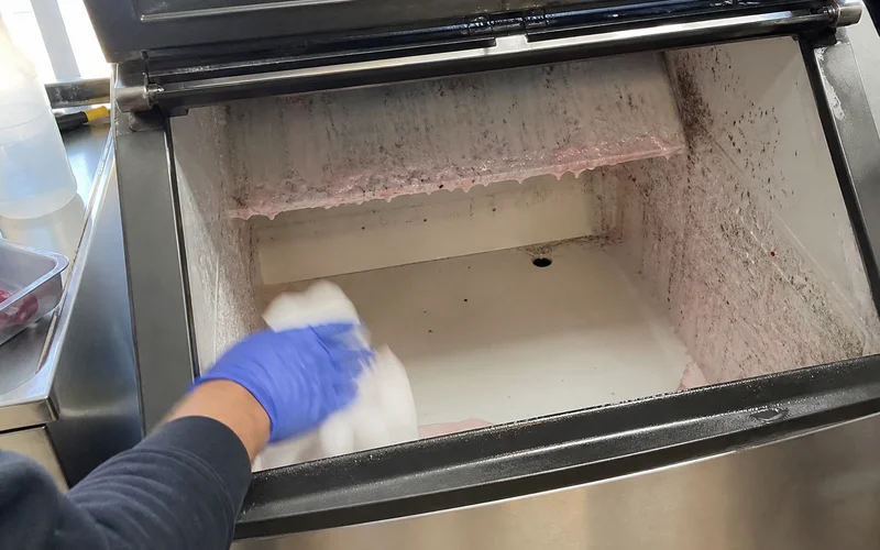 Biofilm buildup inside a neglected commercial ice machine bin