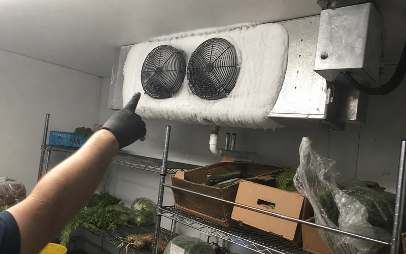 Thick ice buildup on a walk-in cooler evaporator coil found during the emergency call
