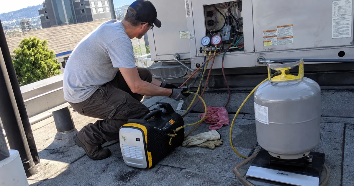 Certified technician recovering refrigerant from a commercial refrigeration system