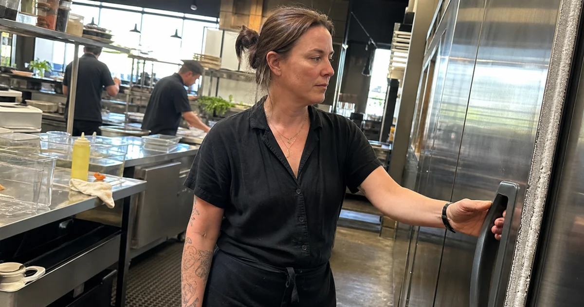 Kitchen manager noticing frost and condensation on a commercial reach-in cooler door