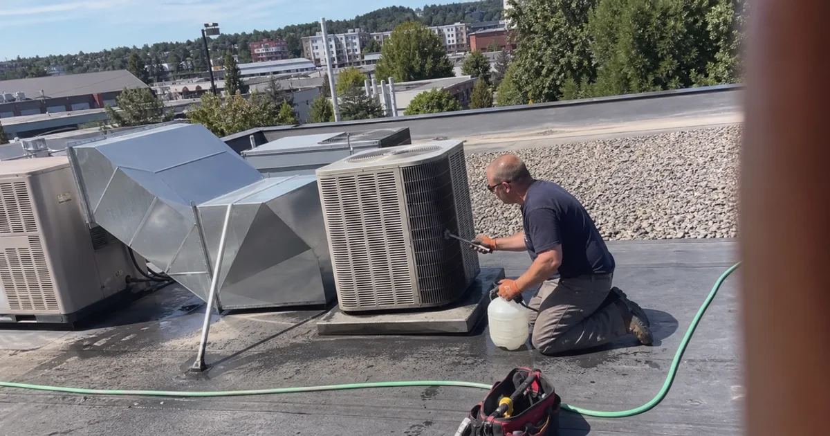 Rooftop refrigeration condensing units in summer sun above a Portland restaurant during coil cleaning