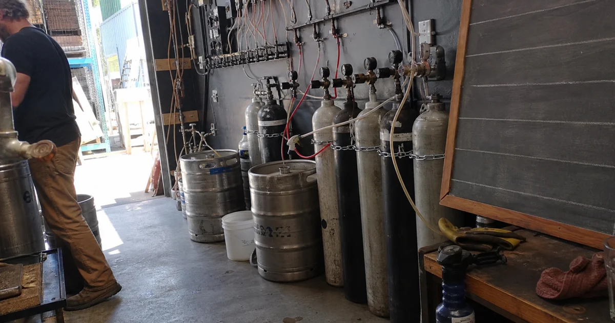Beer gas cylinders and regulators in a Portland taproom cellar feeding draft lines