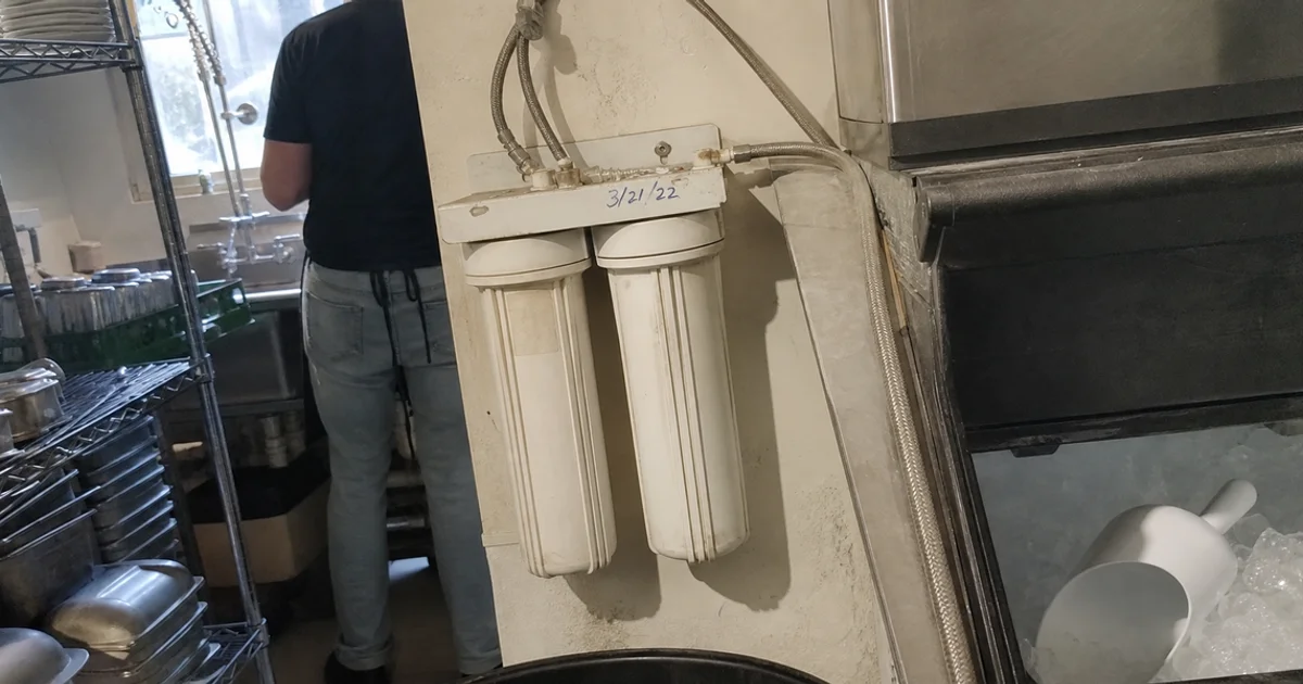 Water filtration cartridges plumbed into a commercial ice machine supply line