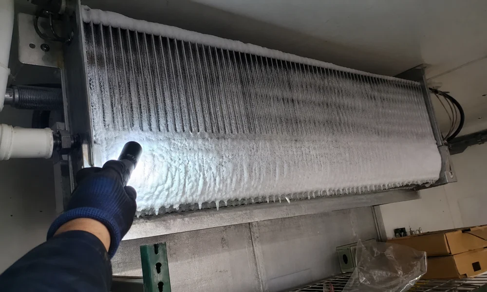 Frost-covered evaporator coil inside a commercial walk-in cooler during a defrost fault diagnosis