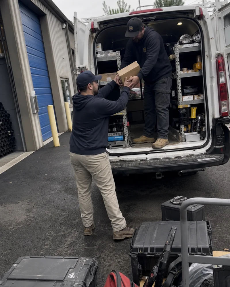 Refrigeration technicians loading parts into a service van outside the Portland shop